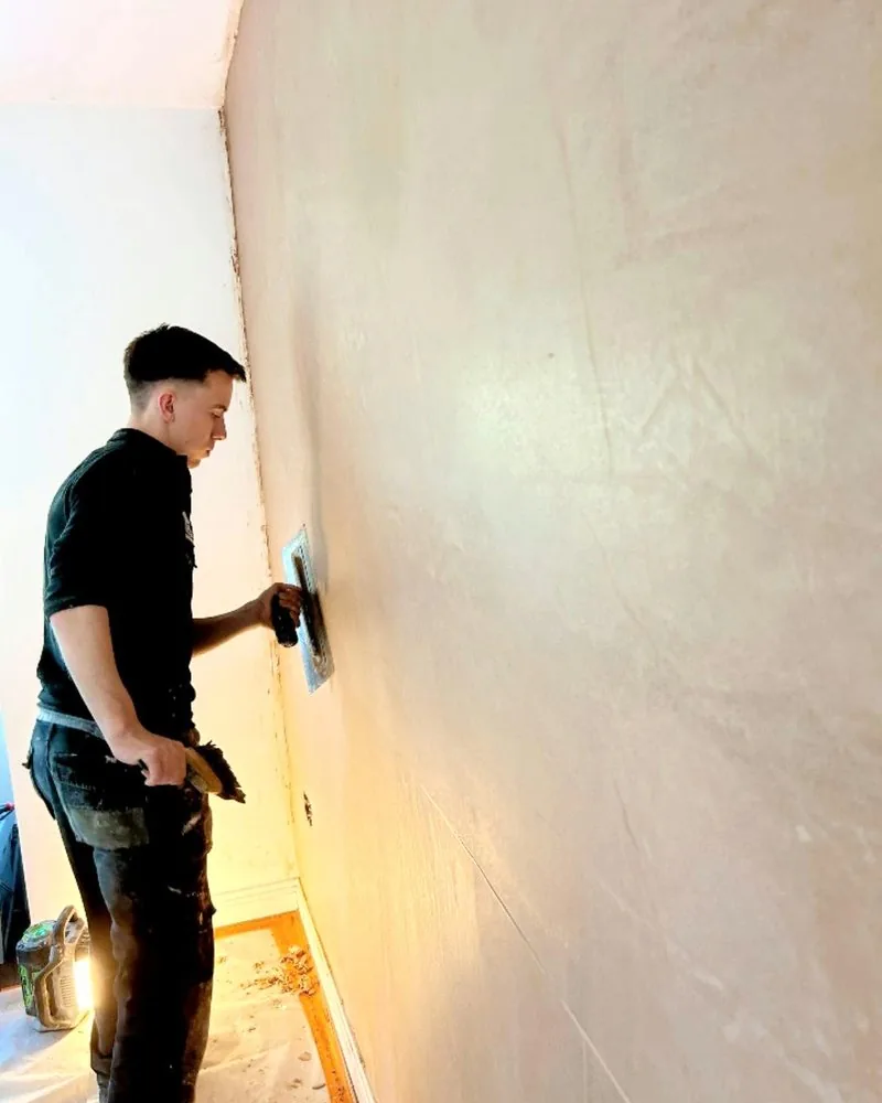 Plastering a wall with a trowel
