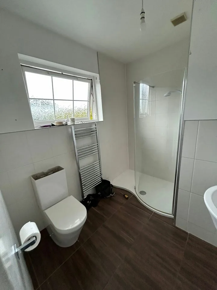 Shower room with curved shower tray and towel radiator