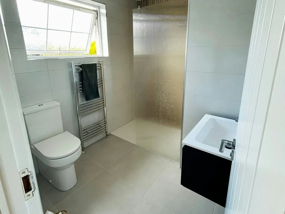Finished shower room with walk-in shower, toilet and vanity unit