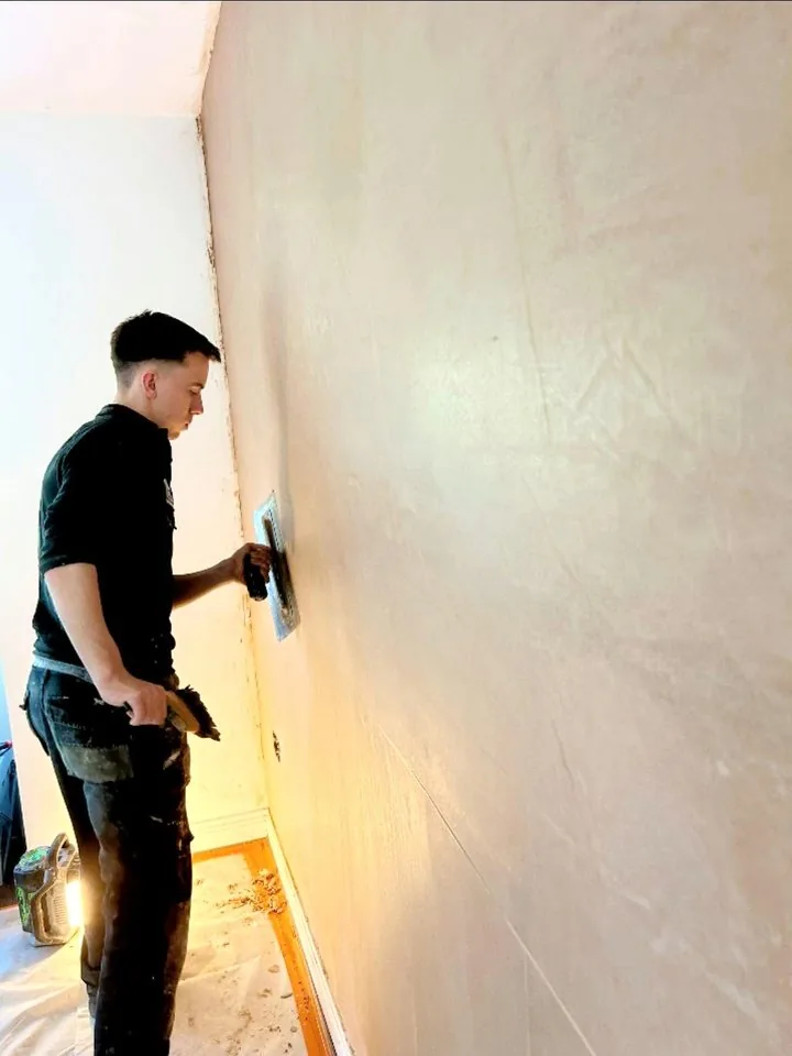 Plastering a wall with a trowel
