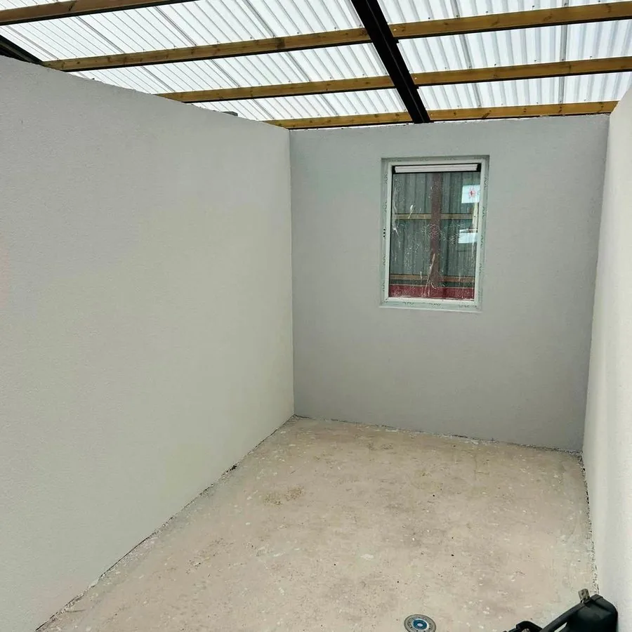 After: the same outbuilding with plastered walls